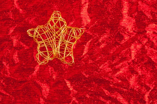 Christmas golden star of wire over red — Stock Photo, Image