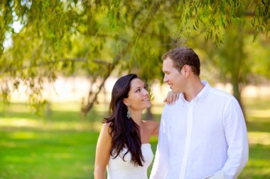 Couple in love happy in green park outdoor clipart