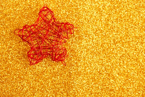 Рождественская золотая звезда из проволоки на золотом блеске — стоковое фото