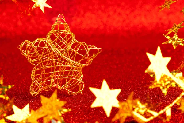 Christmas gold wire star on red glitter — Stock Photo, Image