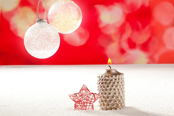 Рождественская серебряная свеча и красная звезда на снегу — стоковое фото