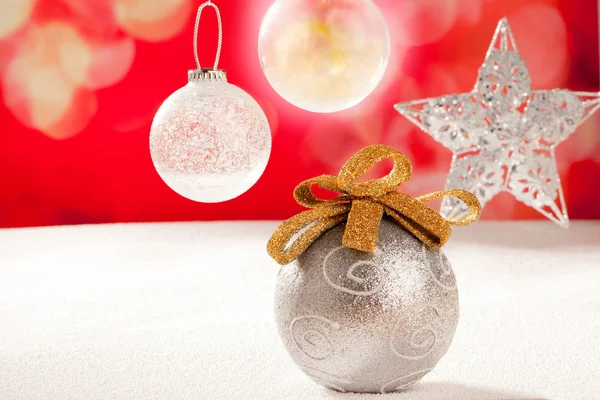 Bola de plata de Navidad y estrella en rojo nieve —  Fotos de Stock