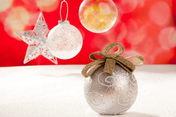 Christmas silver bauble and star on snow red — Stock Photo, Image