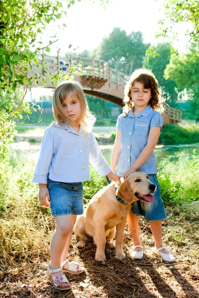 Kid girls with Golden retriever puppy outdoor — Stock Photo, Image