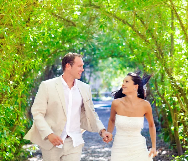 Casal acabou de se casar feliz correndo no parque verde — Fotografia de Stock