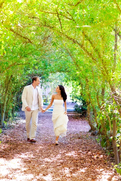 Casal acabou de se casar feliz correndo no parque verde — Fotografia de Stock
