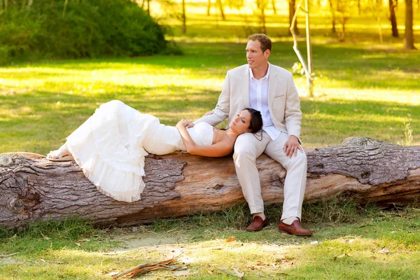 Donna sdraiata sulla gamba del marito in un tronco di parco — Foto Stock