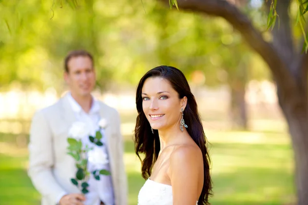 Couple just married with man holding flowers — Stock Photo, Image