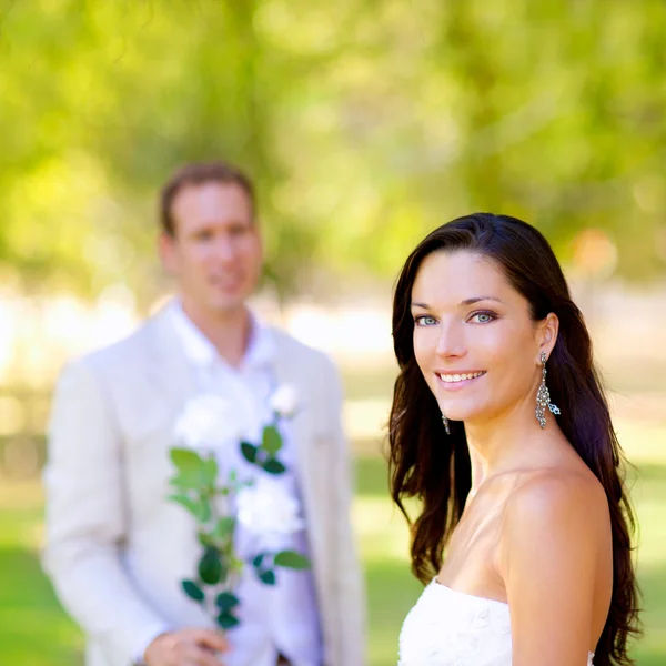 Couple just married with man holding flowers — Stock Photo, Image