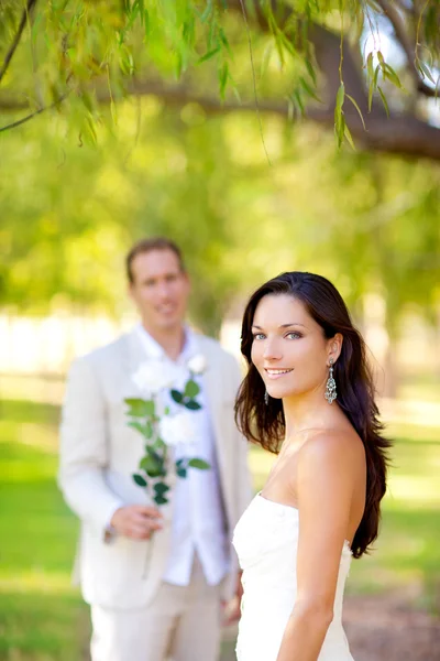 Couple vient de se marier avec homme tenant des fleurs — Photo