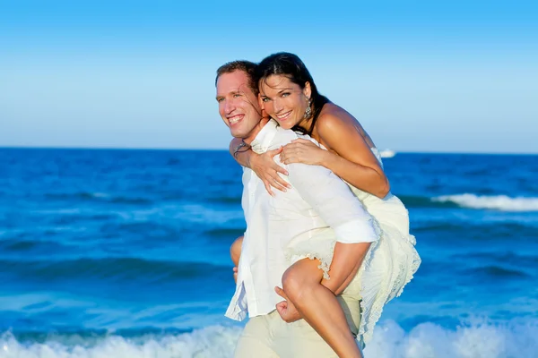愛のカップルはビーチで遊んでピギーバックします。 — ストック写真
