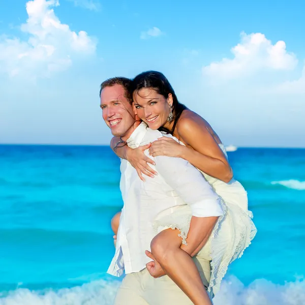 Casal apaixonado piggyback jogando na praia — Fotografia de Stock