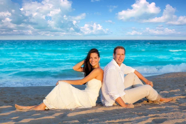 Coppia innamorata seduta in spiaggia blu — Foto Stock