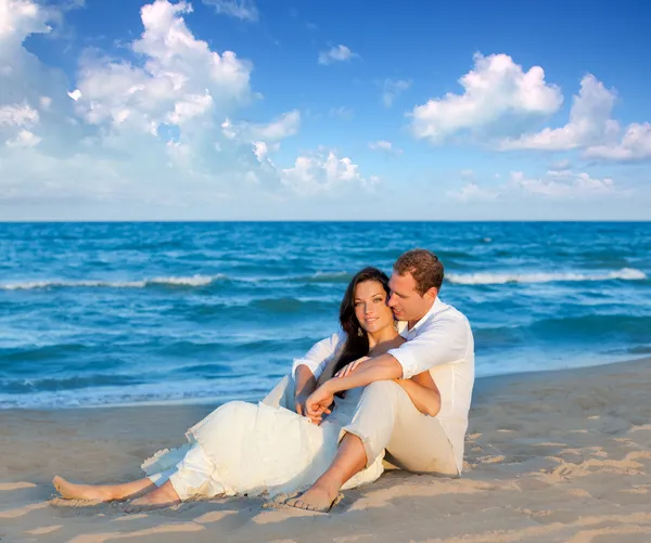 Casal apaixonado sentado na praia azul — Fotografia de Stock
