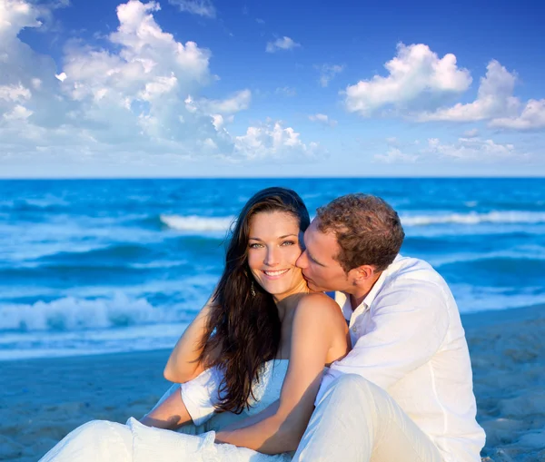Пара влюбленных сидящих на голубом пляже — стоковое фото