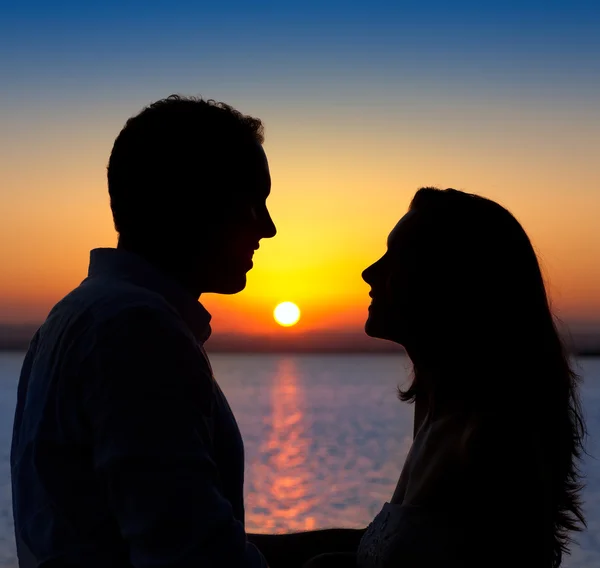 Pár v lásce podsvícení silueta na jezero západ slunce — Stock fotografie