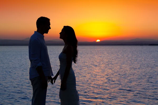 Couple en amour retour silhouette légère au coucher du soleil lac — Photo