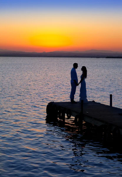 Casal no amor de volta silhueta leve no lago — Fotografia de Stock