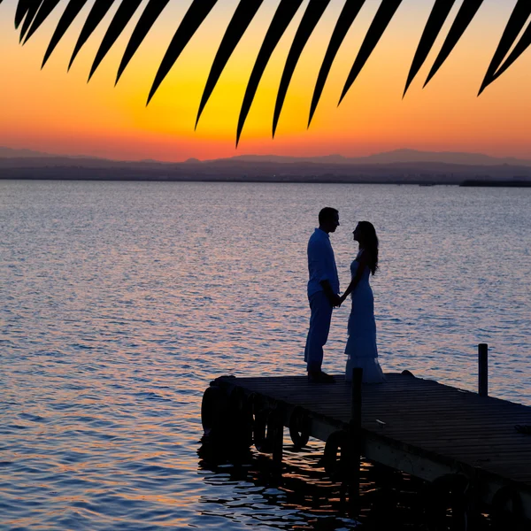 Pár v lásku zpět světlo silueta na jezeře — Stock fotografie