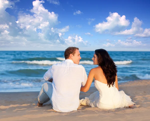 Couple in love sitting in blue beach Stock Image