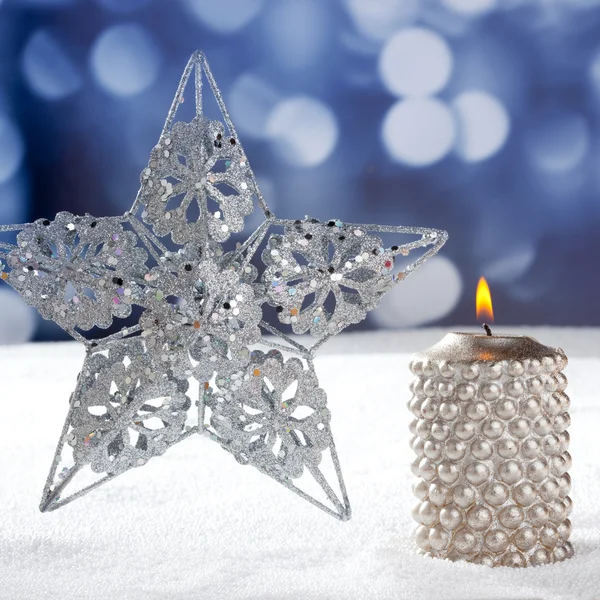 Christmas card of silver star and candle on snow — Stock Photo, Image