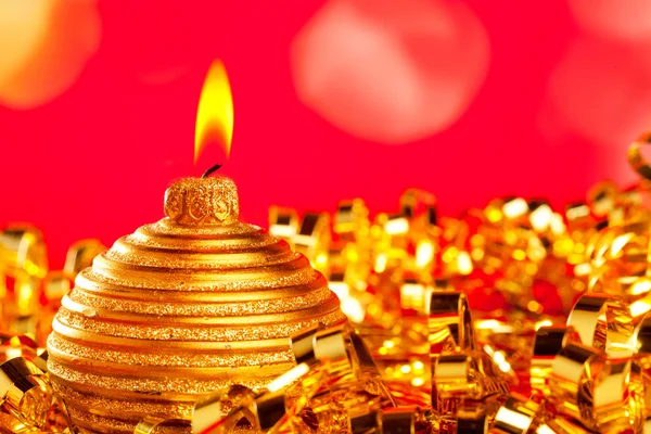 Christmas card of golden bauble candle on tinsel — Stock Photo, Image