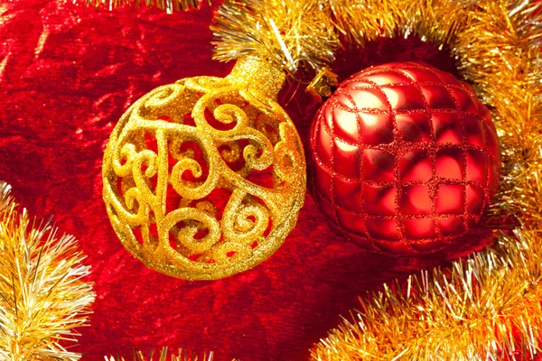 Christmas card golden bauble and tinsel on red — Stock Photo, Image