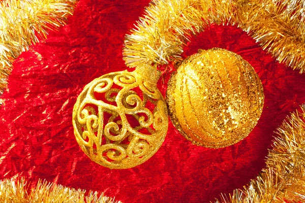Christmas card golden bauble and tinsel on red — Stock Photo, Image