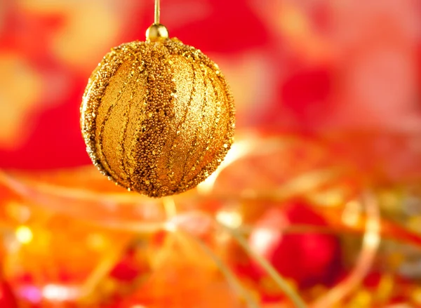 Cartão de Natal de bugiganga dourada e borrão vermelho — Fotografia de Stock