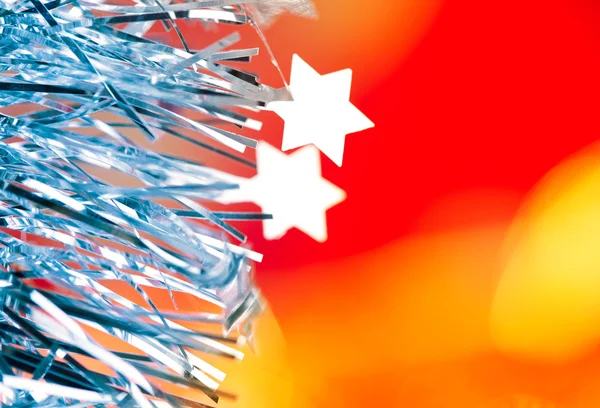 Tinsel de Navidad estrellas de plata azul sobre rojo — Foto de Stock