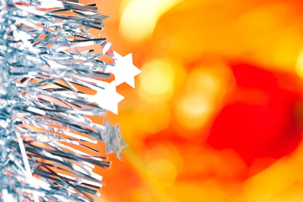 Tinsel de Navidad estrellas de plata azul sobre rojo — Foto de Stock