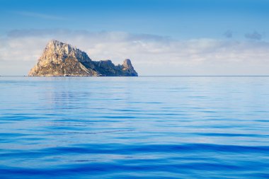 Ibiza Es Vedra island in calm blue water clipart