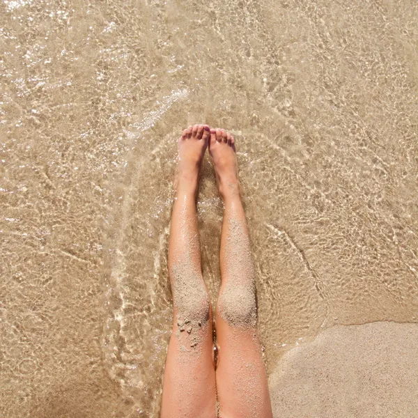 Barn tjej ben i stranden sand stranden — Stockfoto