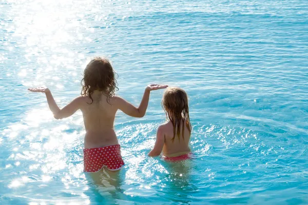 Τα παιδιά τα κορίτσια πίσω θέα στην παραλία στο ηλιοβασίλεμα — Φωτογραφία Αρχείου