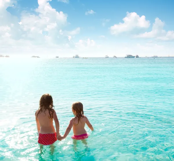 Дети девочки задний вид на пляж на закате — стоковое фото