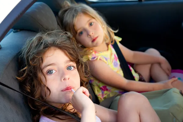 Holčičky uvnitř auta jíst cukroví držet — Stock fotografie