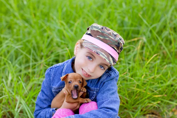 Küçük kız evde beslenen hayvan köpek yavrusu maskot mini pinscher — Stok fotoğraf