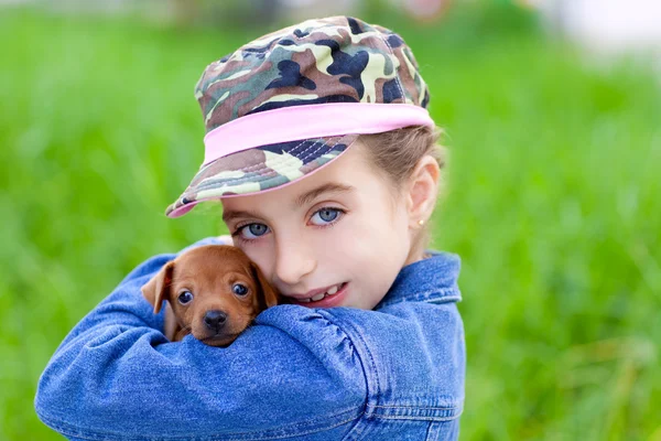 Küçük kız evde beslenen hayvan köpek yavrusu maskot mini pinscher — Stok fotoğraf