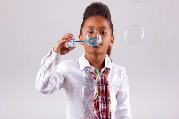 Kleine Afrikaanse Aziatische meisje zeepbellen blazen — Stockfoto