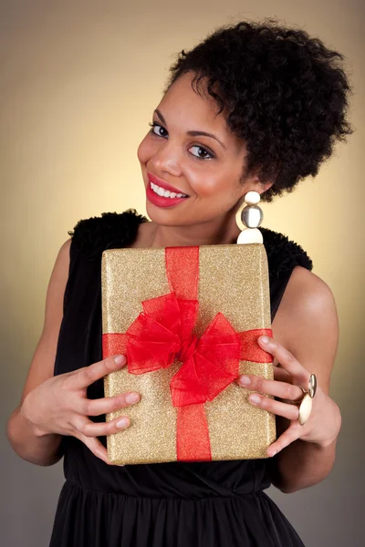 युवा अफ्रीकी-अमेरिकी महिला एक उपहार पकड़े हुए — स्टॉक फ़ोटो, इमेज