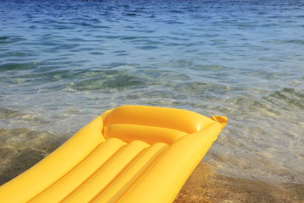 stock image Yellow air mattress on the beach