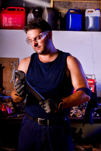 View of a garage mechanic man holding a wrench.