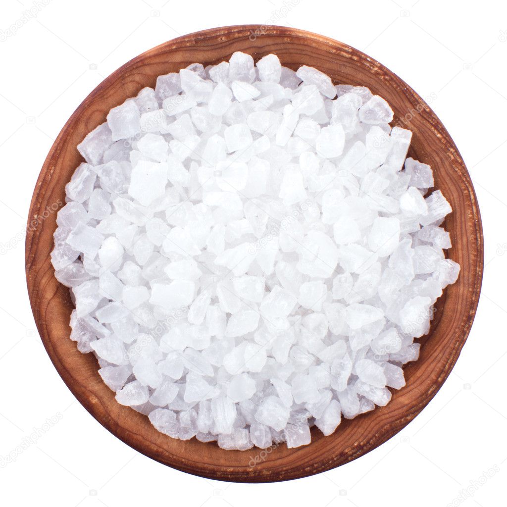 Wooden bowl full of sea salt over white
