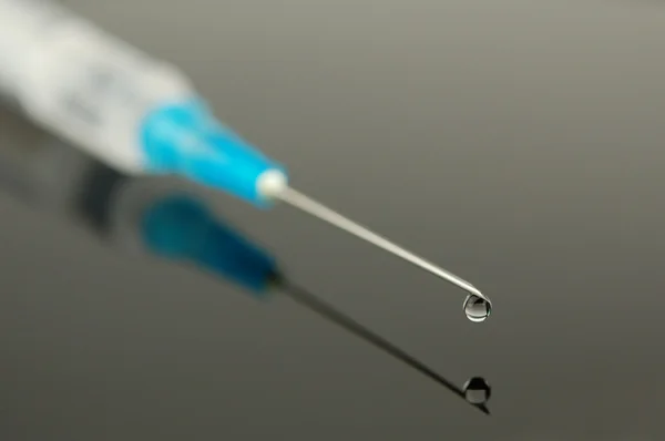 Syringe with a drop — Stock Photo, Image