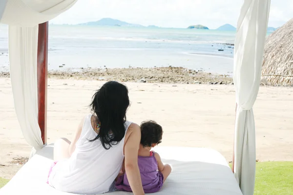 Mom with a child watching the beach on the bed — Stock Photo, Image