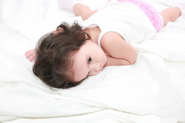 Αξιολάτρευτο μικρό παιδί κορίτσι στο κρεβάτι στο σπίτι — Φωτογραφία Αρχείου