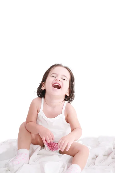 Laughing little girl on her bed — Stock Photo, Image
