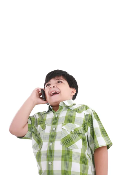 Menino bonito ri e fala por telefone celular . — Fotografia de Stock