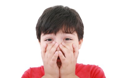 Preschool aged boy with his hand/fists over his mouth; looking e clipart