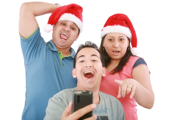 Young friends looking shocked at cell phone with Christmas hat — Stock Photo, Image